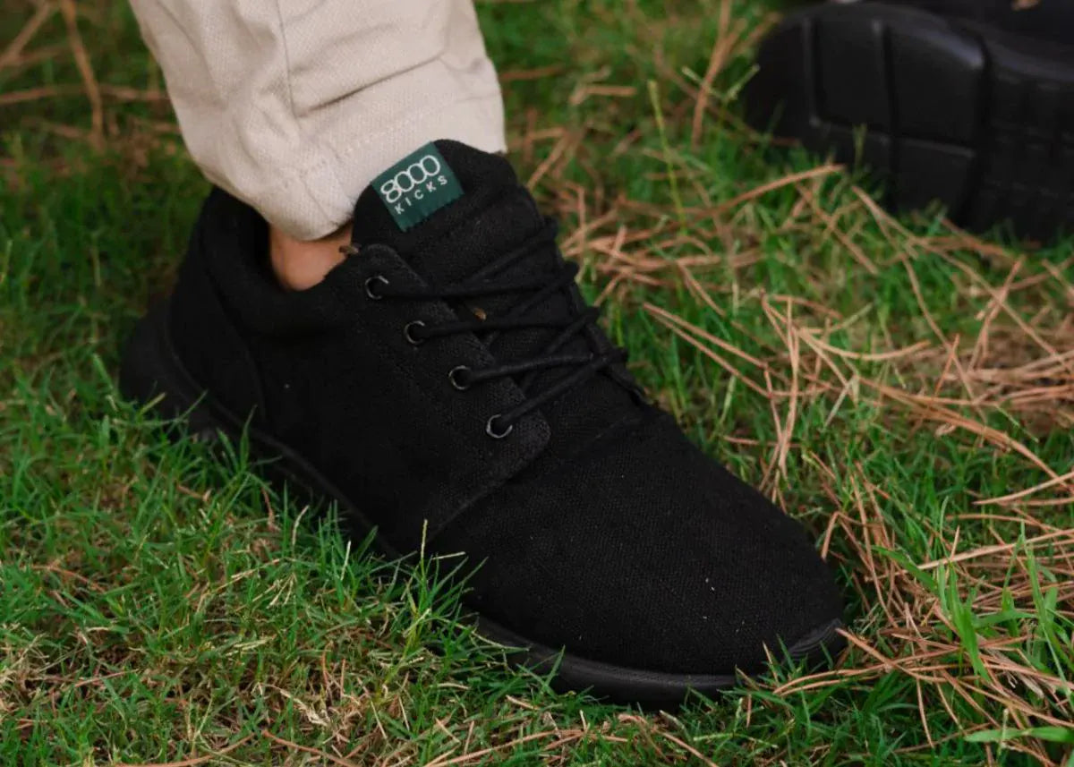 A man wearing a black pair of hemp Explorer V2 shoes.